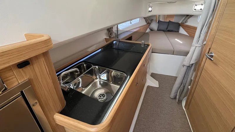 In- Stock 2025 Nimbus C11 #086 Yacht Photos Pics Modern interior of 2025 Nimbus Commuter 11 #086 with kitchenette and cozy sleeping area.