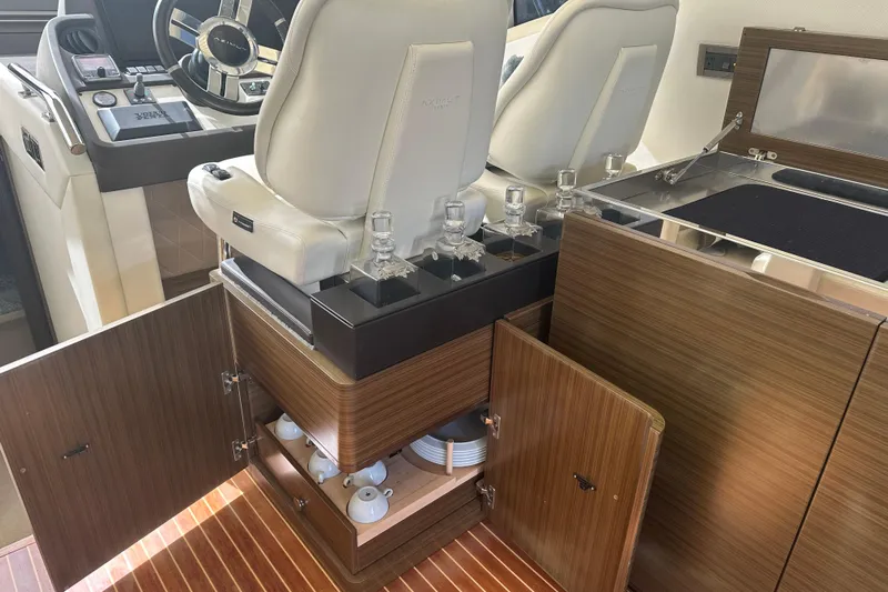 Radio Waves Yacht Photos Pics 2015 Azimut 55S yacht interior with helm, white seats, and wooden cabinetry.