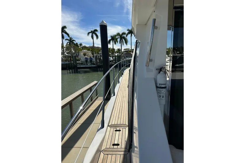 Radio Waves Yacht Photos Pics Side view of 2015 Azimut 55S yacht docked by palm trees.