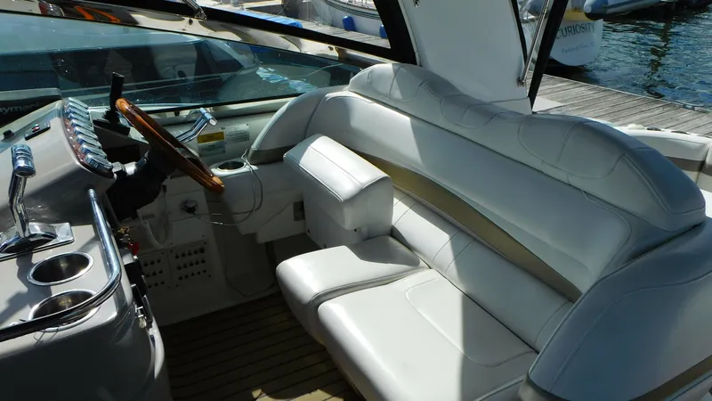  Yacht Photos Pics 2003 Formula 40 PC yacht cockpit with white leather seating and wooden steering wheel.