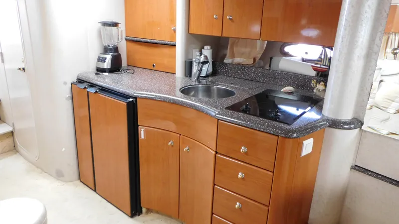  Yacht Photos Pics 2003 Formula 40 PC yacht kitchen with wood cabinets, sink, stove, and blender.
