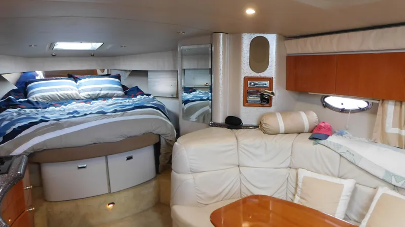  Yacht Photos Pics 2003 Formula 40 PC yacht interior with cozy bed, seating area, and wooden accents.