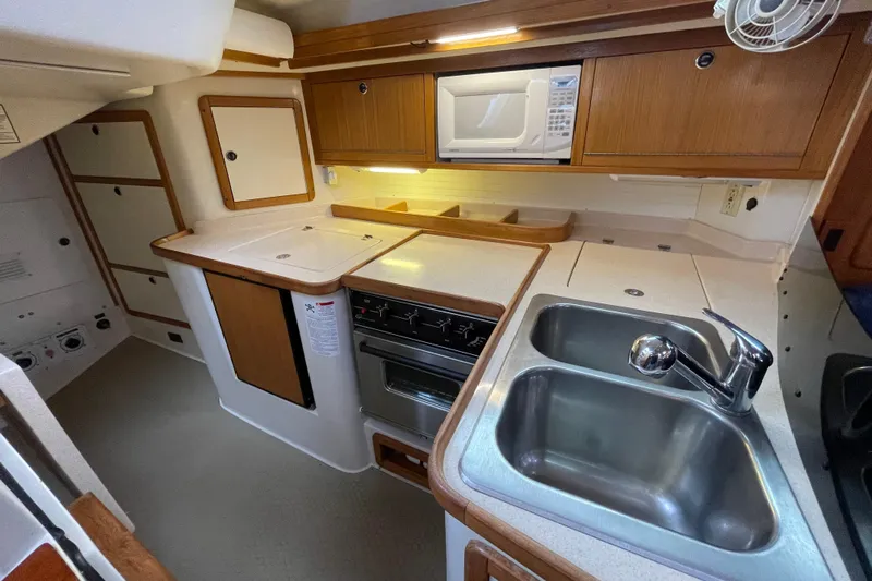 Buena Vida Yacht Photos Pics Galley kitchen in 2000 Catalina 42 MkII sailboat with sink, stove, and microwave.