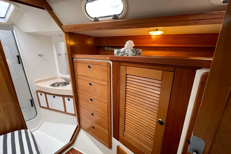 Buena Vida Yacht Photos Pics Interior of 2000 Catalina 42 MkII sailboat with wooden cabinetry and compact bathroom.