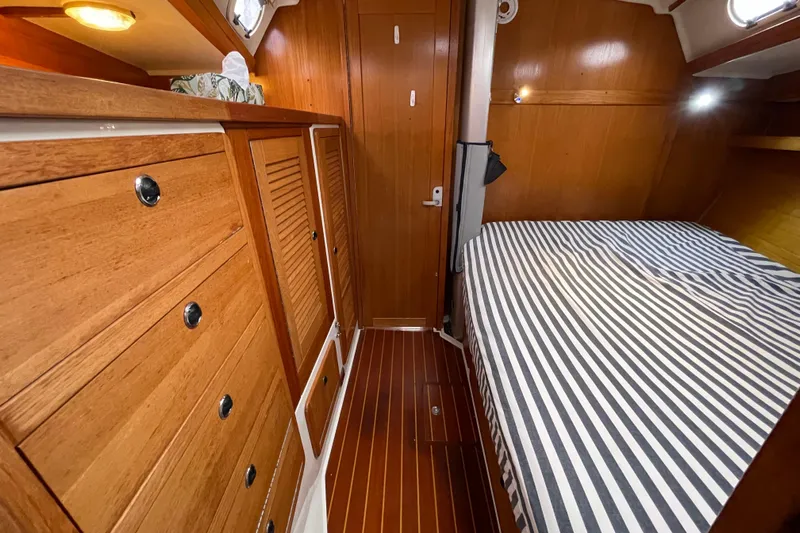 Buena Vida Yacht Photos Pics Interior of 2000 Catalina 42 MkII sailboat with wood cabinetry and striped bedding.