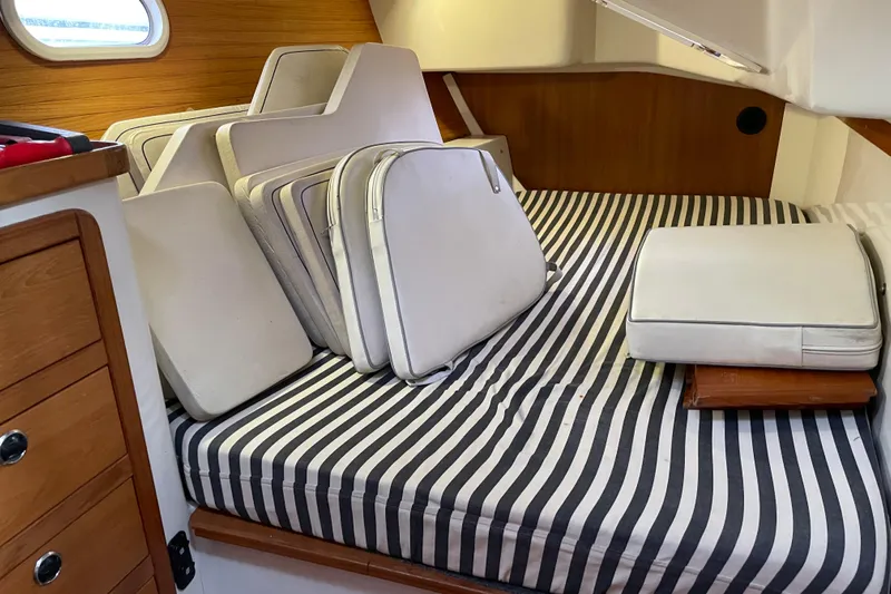 Buena Vida Yacht Photos Pics Interior of 2000 Catalina 42 MkII sailboat with striped bedding and white cushions.