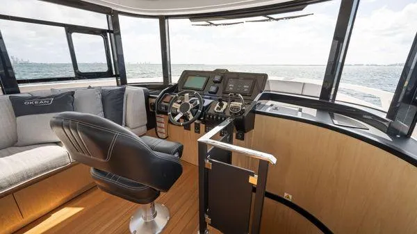  Yacht Photos Pics 2024 OKEAN 52 yacht interior with modern helm, leather chair, and panoramic windows.