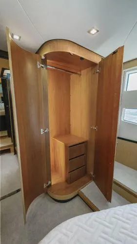  Yacht Photos Pics 2024 OKEAN 52 yacht interior with open wooden wardrobe and drawers.