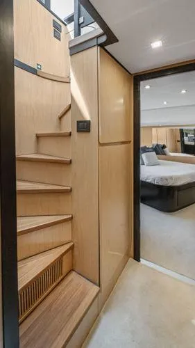  Yacht Photos Pics Interior of 2024 OKEAN 52 yacht featuring wooden stairs and a luxurious bedroom.