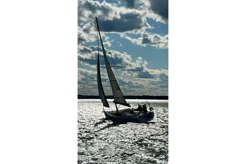  Yacht Photos Pics Sailing yacht Beneteau Oceanis 40, 2010 model, gliding on shimmering water under cloudy sky.