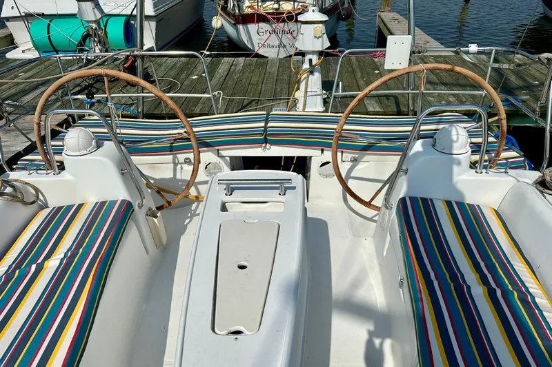  Yacht Photos Pics Cockpit of 2010 Beneteau Oceanis 40 sailboat with striped cushions and dual steering wheels.