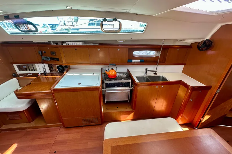  Yacht Photos Pics Interior of 2010 Beneteau Oceanis 40 yacht kitchen with wooden cabinetry and modern appliances.