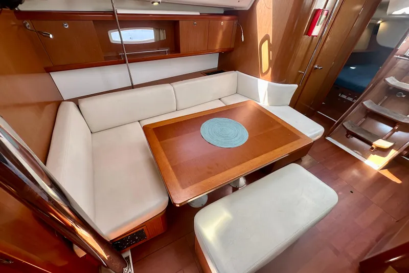  Yacht Photos Pics Interior of 2010 Beneteau Oceanis 40 sailboat with cozy seating and wooden table.