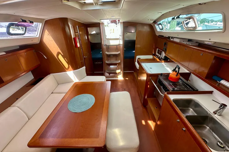 Yacht Photos Pics Interior of 2010 Beneteau Oceanis 40 yacht with kitchen, dining area, and wooden cabinetry.