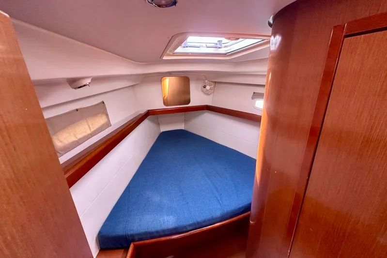  Yacht Photos Pics Cozy cabin interior of 2010 Beneteau Oceanis 40 sailboat with blue bedding.