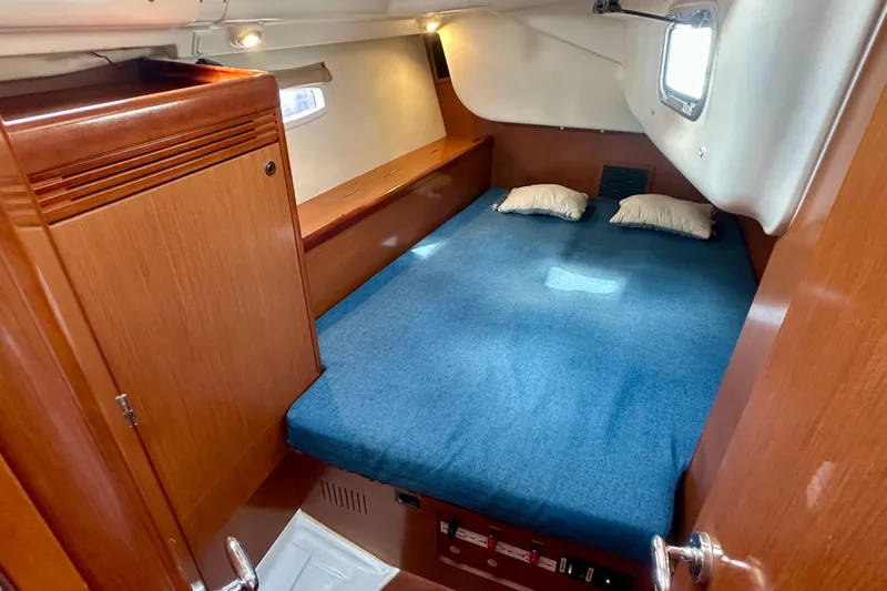  Yacht Photos Pics Cozy cabin interior of 2010 Beneteau Oceanis 40 sailboat with blue bedding.