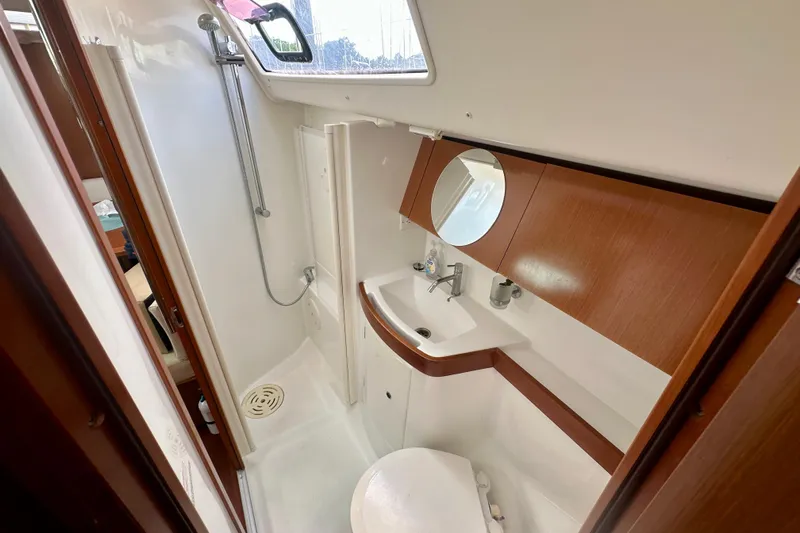  Yacht Photos Pics Bathroom interior of 2010 Beneteau Oceanis 40 yacht, featuring shower, sink, and wooden cabinetry.