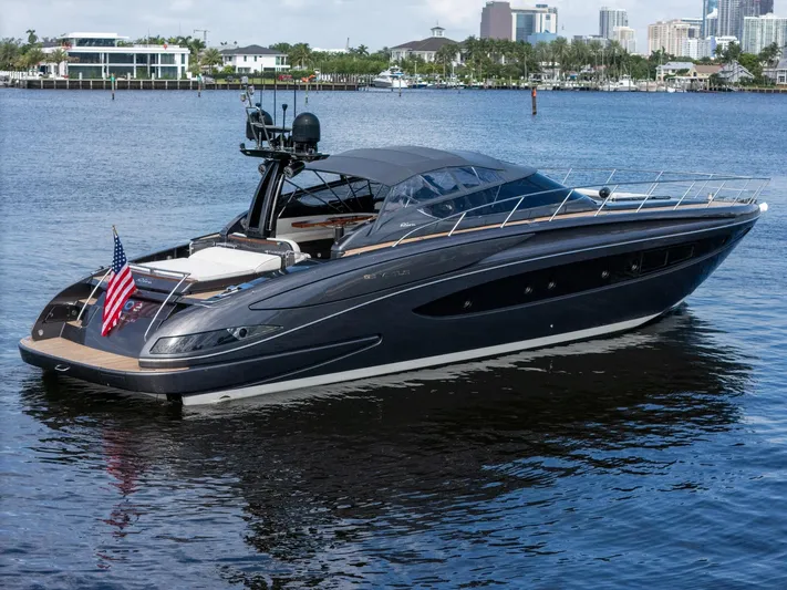 Joe Yacht Photos Pics Luxury 2015 Riva 63 Virtus yacht on calm water, cityscape background.