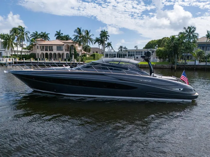 Joe Yacht Photos Pics 2015 Riva 63 Virtus yacht cruising on a scenic waterway with luxury homes in the background.