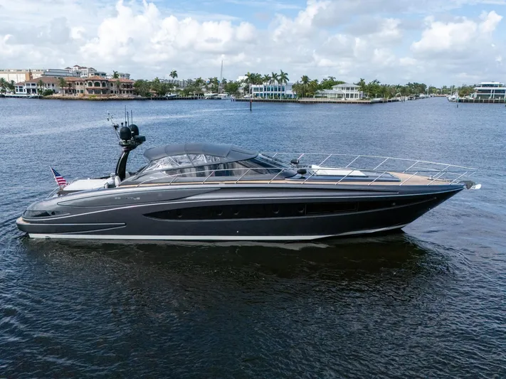 Joe Yacht Photos Pics 2015 Riva 63 Virtus luxury yacht cruising on a calm waterway under a partly cloudy sky.