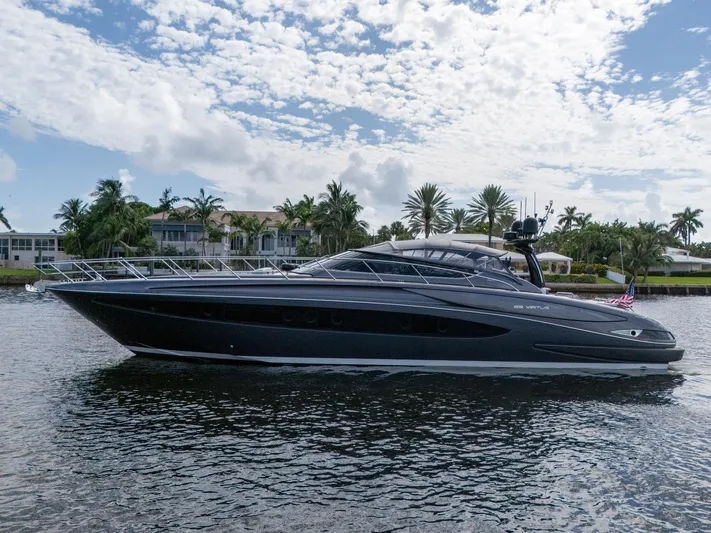 Joe Yacht Photos Pics 2015 Riva 63 Virtus yacht on water, with palm trees and houses in the background.