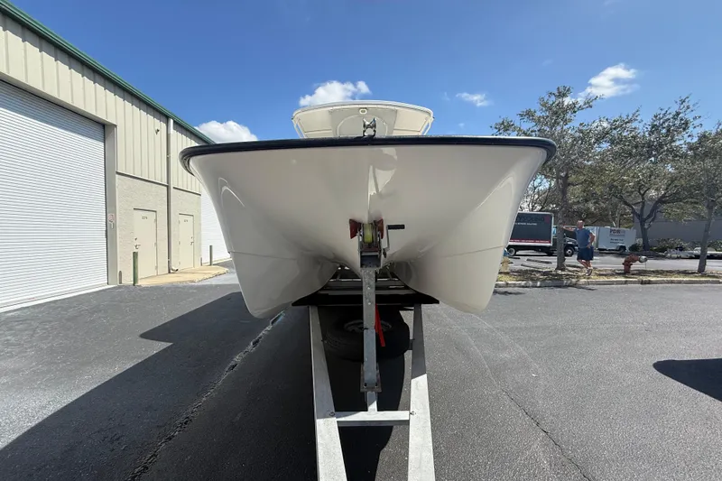  Yacht Photos Pics 2019 Calcutta 263 boat on trailer, parked outside industrial building under clear sky.