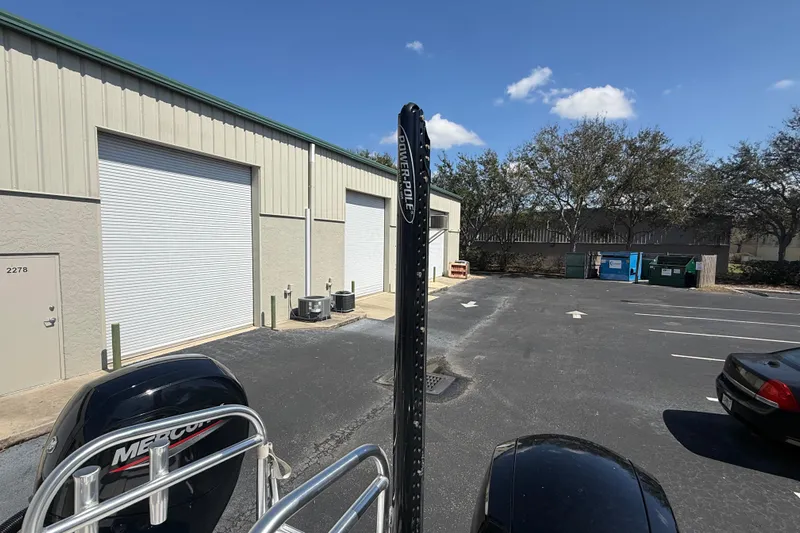  Yacht Photos Pics Outdoor view of a Calcutta 263 boat near storage units, featuring a Power-Pole and Mercury engine.