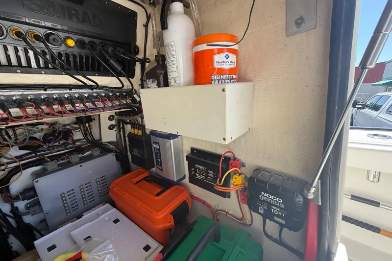  Yacht Photos Pics Electrical panel and storage in a 2019 Calcutta 263 boat, featuring wiring and equipment.