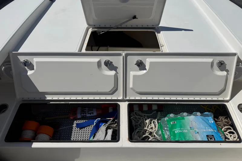  Yacht Photos Pics Open storage compartments on a 2019 Calcutta 263 boat, containing ropes and supplies.