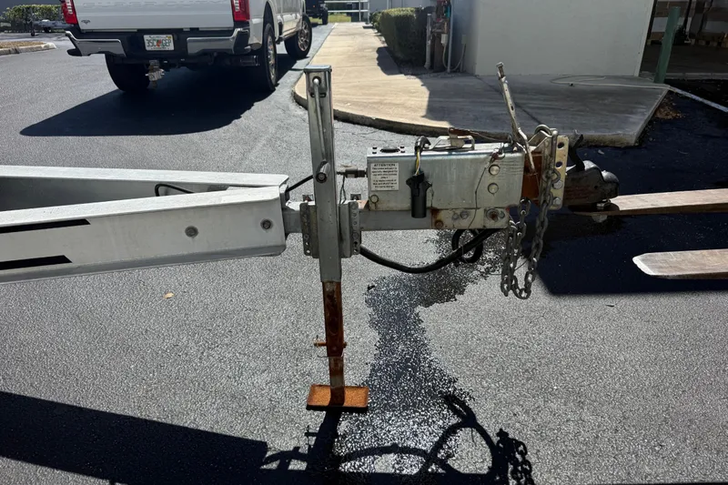  Yacht Photos Pics Trailer hitch of a 2019 Calcutta 263 on asphalt, with a parked truck nearby.