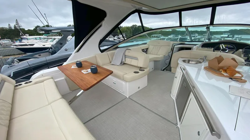  Yacht Photos Pics 2021 Regal 33 Express yacht interior with seating, table, and kitchenette.