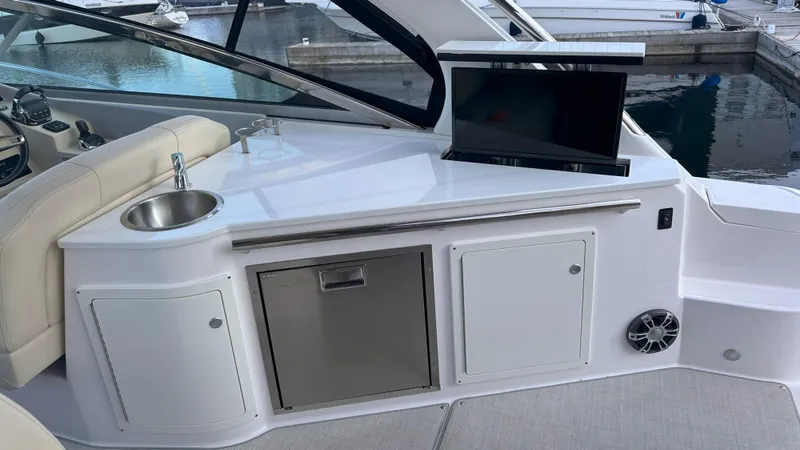  Yacht Photos Pics 2021 Regal 33 Express boat interior with sink, TV, and storage compartments.