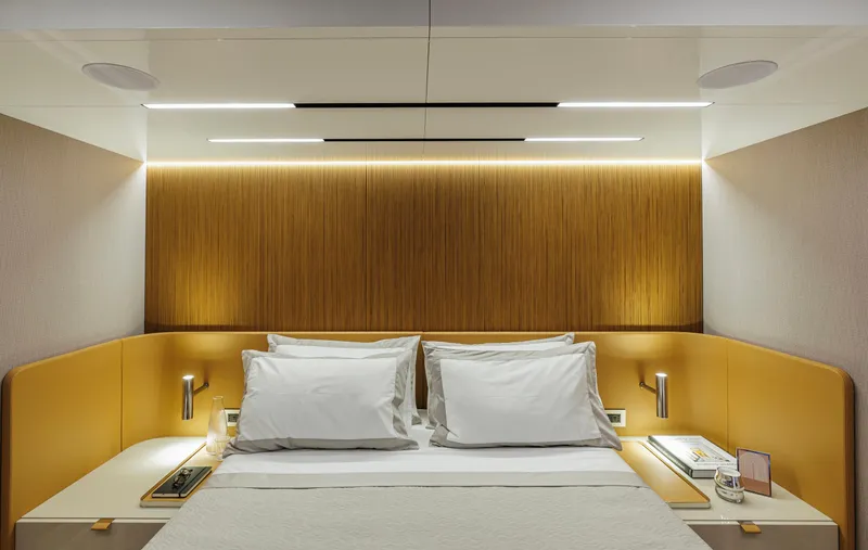  Yacht Photos Pics Luxurious bedroom interior of 2025 Cranchi Sessantadue 62 yacht with modern lighting and design.