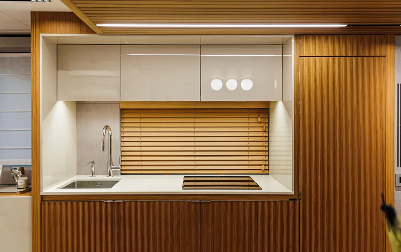  Yacht Photos Pics Modern kitchen interior on 2025 Cranchi Sessantadue 62 yacht, featuring sleek wood paneling and minimalist design.