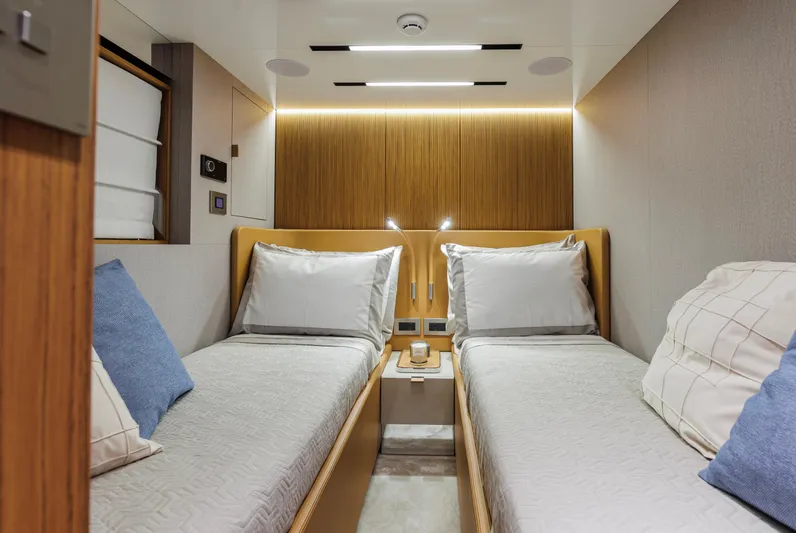  Yacht Photos Pics Luxurious twin cabin interior of 2025 Cranchi Sessantadue 62 yacht, featuring modern design and cozy bedding.