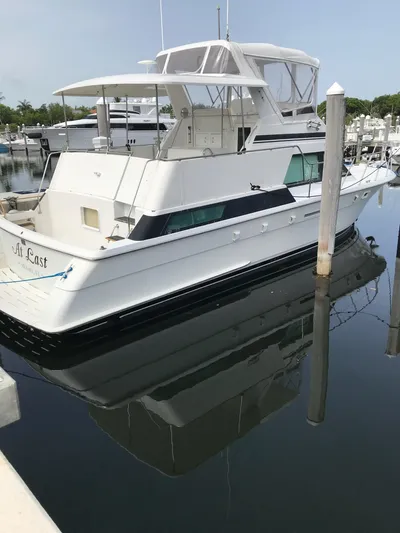 Yacht Photos Pics 1994 Hatteras 42 Cockpit Motor Yacht docked in a marina, reflecting on calm water.
