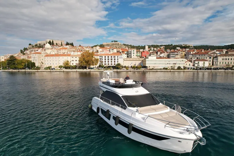  Yacht Photos Pics 2024 Azimut Fly 53 yacht cruising near a picturesque coastal town.
