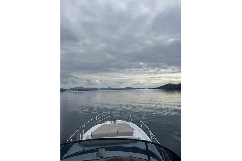  Yacht Photos Pics 2024 Azimut Fly 53 yacht cruising on calm waters under cloudy skies.