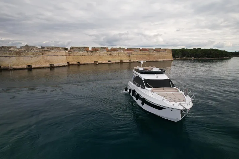  Yacht Photos Pics 2024 Azimut Fly 53 yacht cruising near historic stone fort on calm waters.