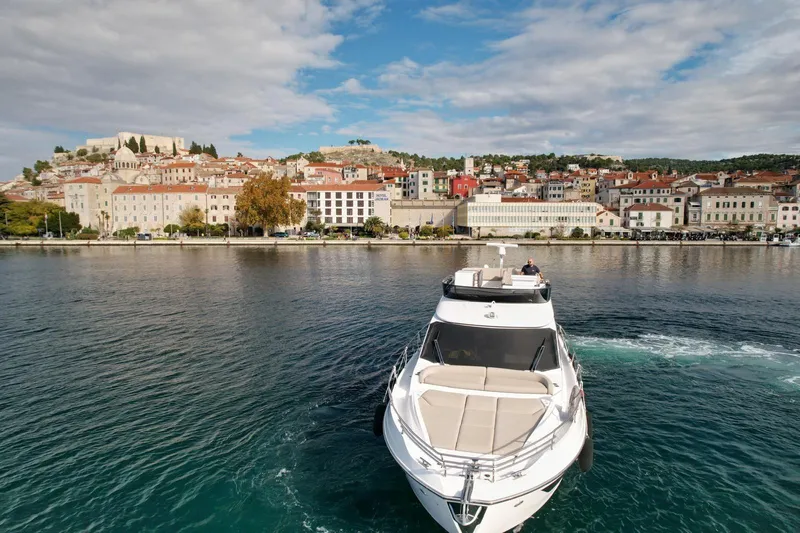  Yacht Photos Pics 2024 Azimut Fly 53 yacht cruising near a picturesque coastal town.