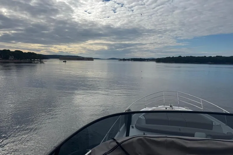  Yacht Photos Pics 2024 Azimut Fly 53 yacht cruising on a serene, cloudy waterway.