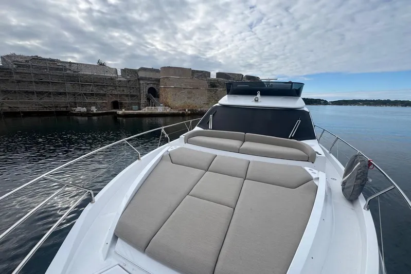  Yacht Photos Pics 2024 Azimut Fly 53 yacht docked near historic stone fort, under cloudy sky.