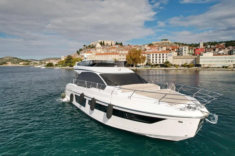  Yacht Photos Pics 2024 Azimut Fly 53 yacht cruising near a scenic coastal town.