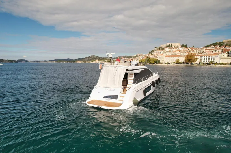  Yacht Photos Pics 2024 Azimut Fly 53 yacht cruising near a scenic coastal town.