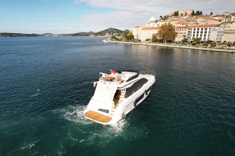  Yacht Photos Pics 2024 Azimut Fly 53 yacht cruising near scenic coastal town.