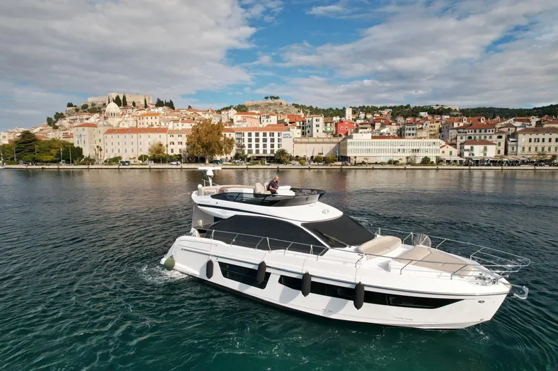  Yacht Photos Pics 2024 Azimut Fly 53 yacht cruising near a scenic coastal town.