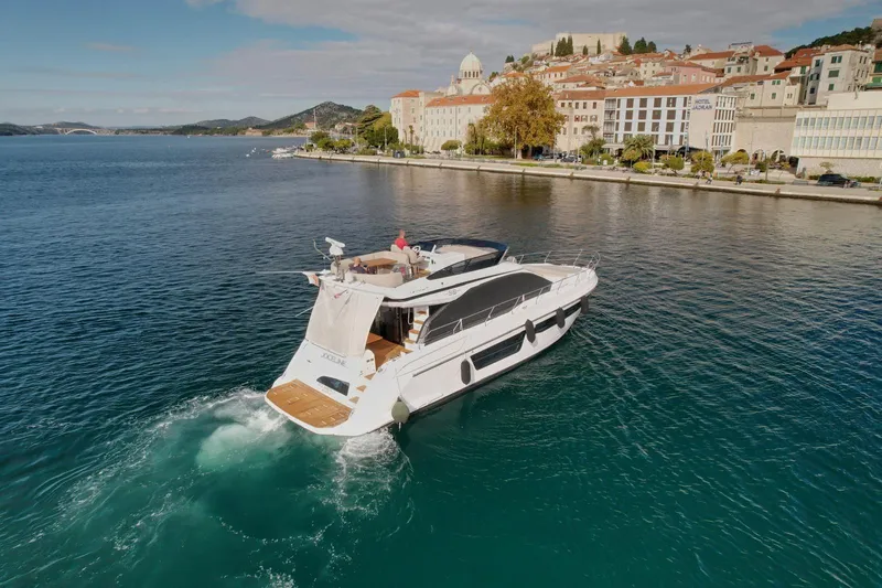  Yacht Photos Pics Luxurious 2024 Azimut Fly 53 yacht cruising near a scenic coastal town.