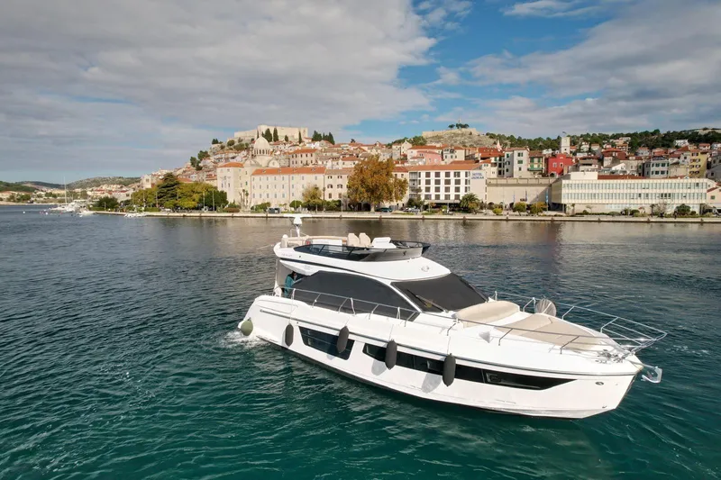  Yacht Photos Pics 2024 Azimut Fly 53 yacht cruising near a scenic coastal town.