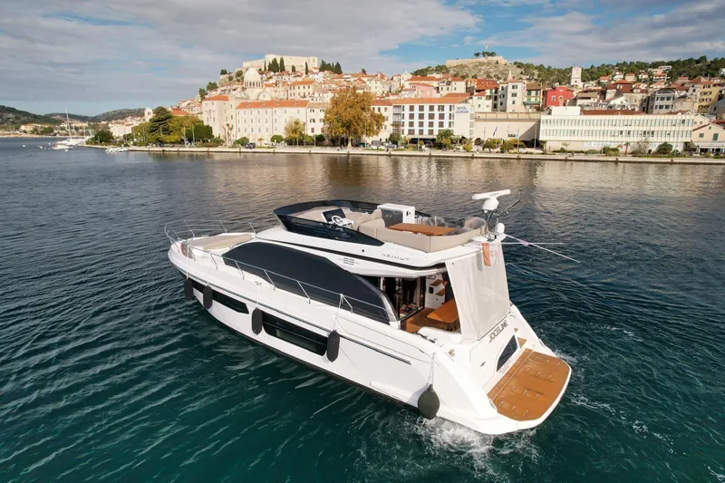  Yacht Photos Pics 2024 Azimut Fly 53 yacht cruising near a scenic coastal town.