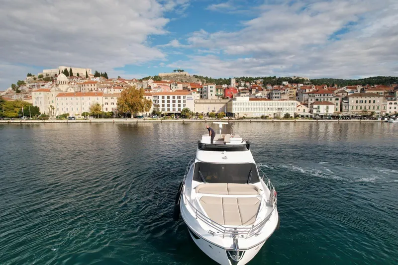  Yacht Photos Pics 2024 Azimut Fly 53 yacht cruising near a picturesque coastal town.